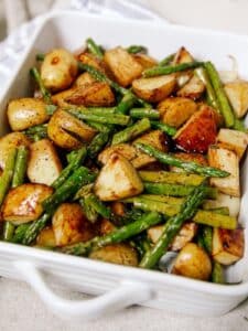 Casserole dish with roasted potatoes and asparagus.