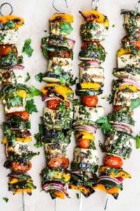 Tofu and veggie skewers topped with fresh herb sauce.