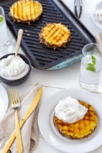 Grilled slices of pineapple and coconut cream in a bowl.