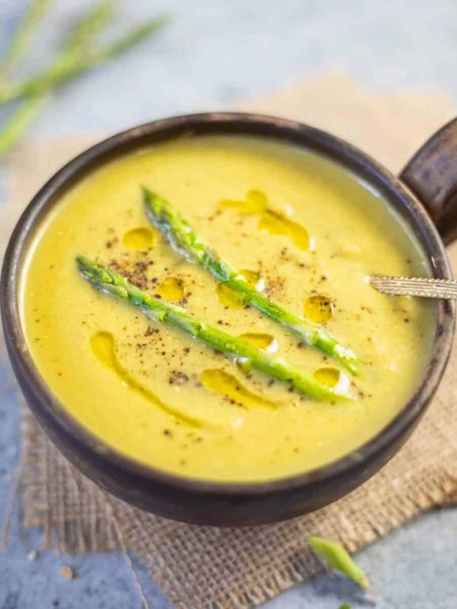 Bowl of soup garnished with asparagus spears.