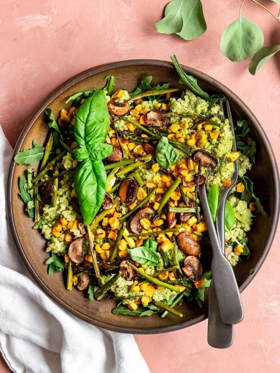 Pesto Quinoa Bowl garnished with fresh basil leaves.