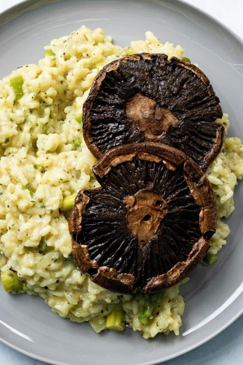 Plate of risotto topped with two shiitake mushrooms.