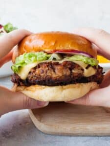 Hands holding veggie burger.