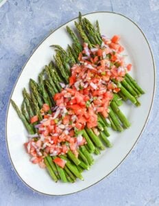 Platter of asparagus topped with pico de gallo.