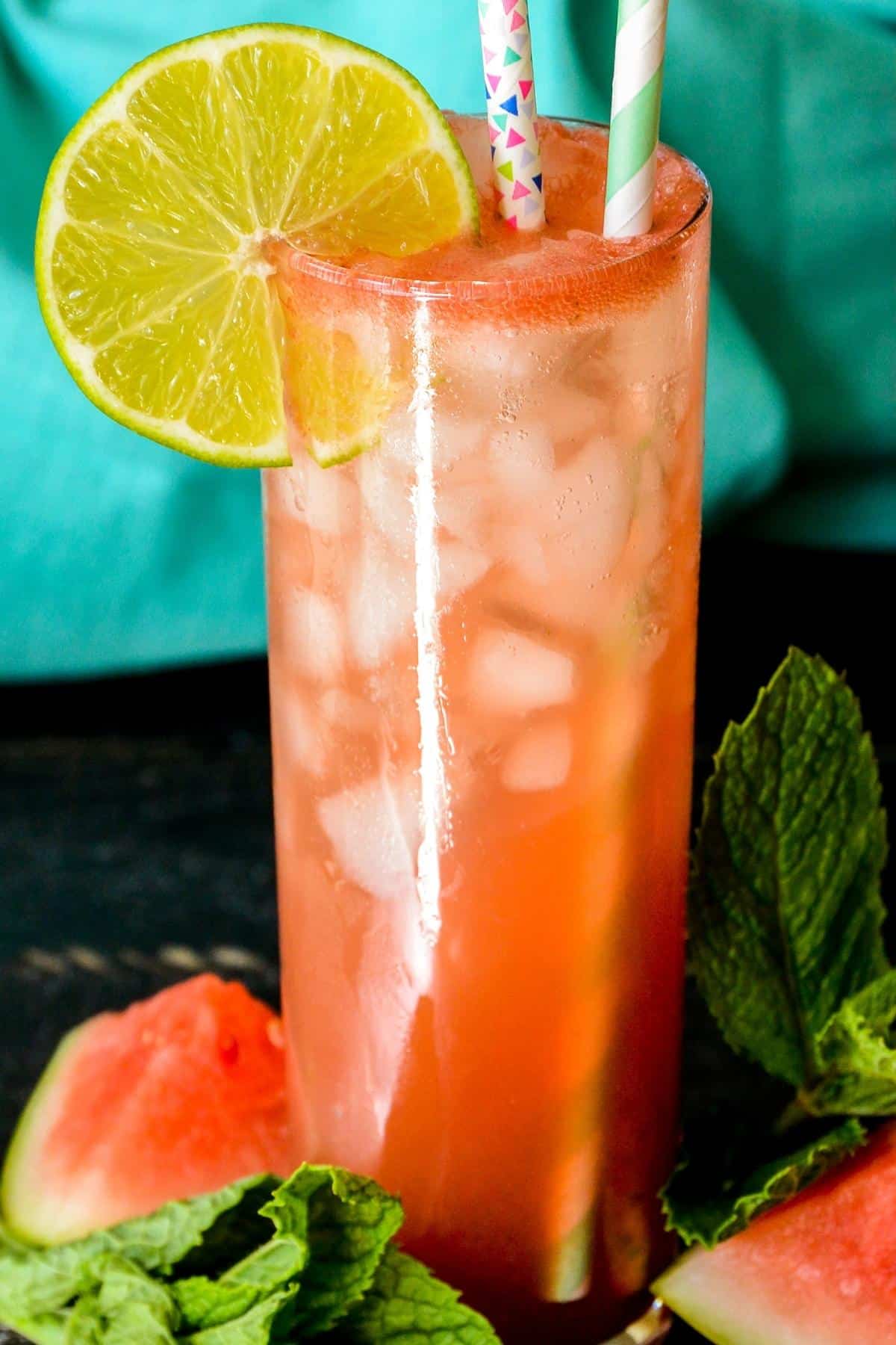 Close up of tall glass of Sparkling Watermelon Refresher garnished with lime.