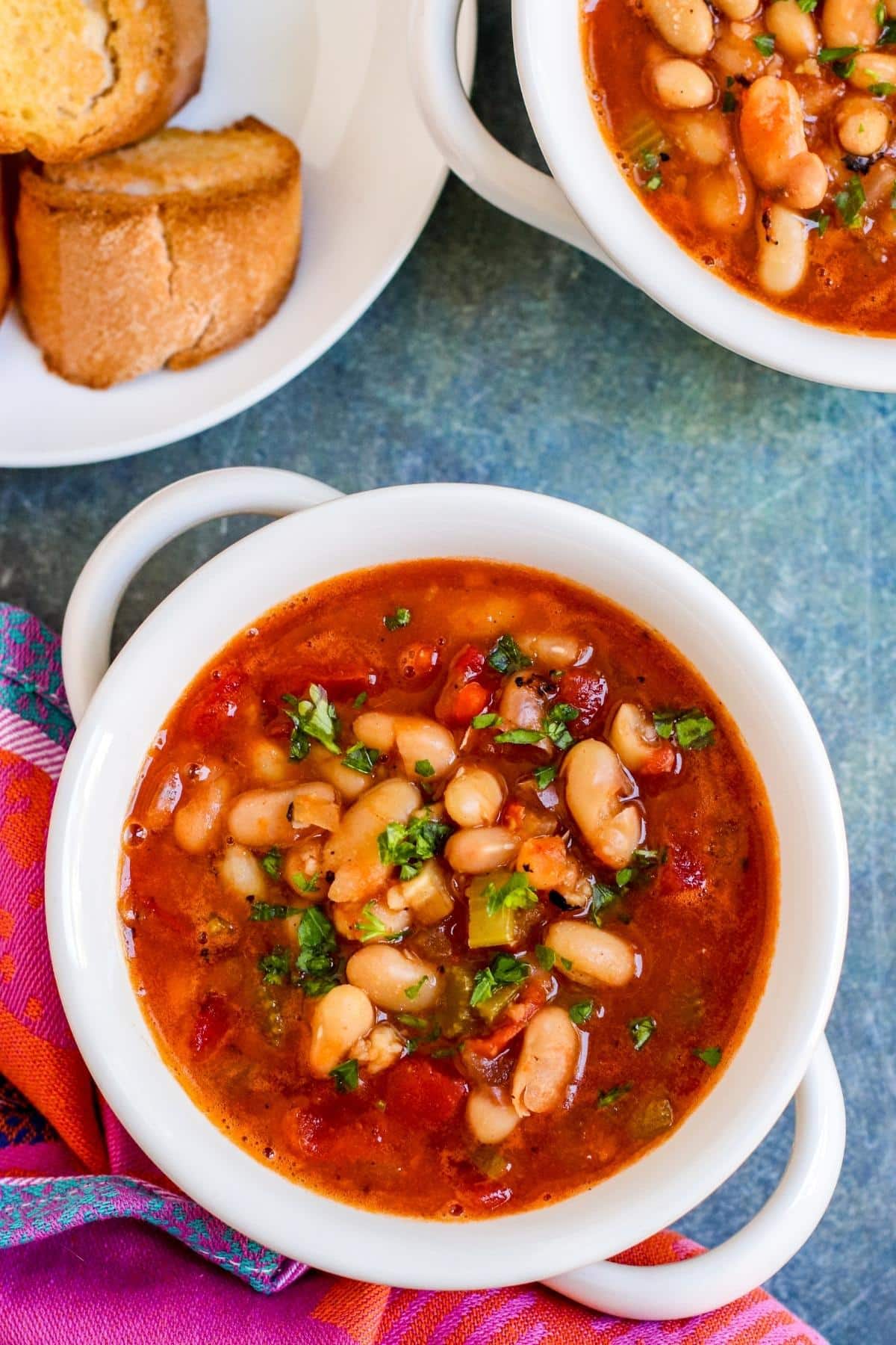 Bowls of soup with plate of toasted baguette.