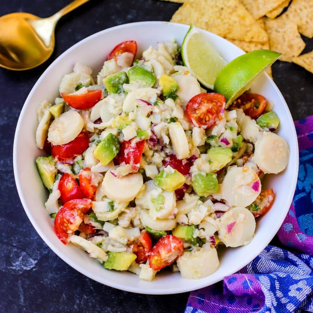 Bowl of Hearts of Palm Ceviche with tortilla chips and a spoon on the side.