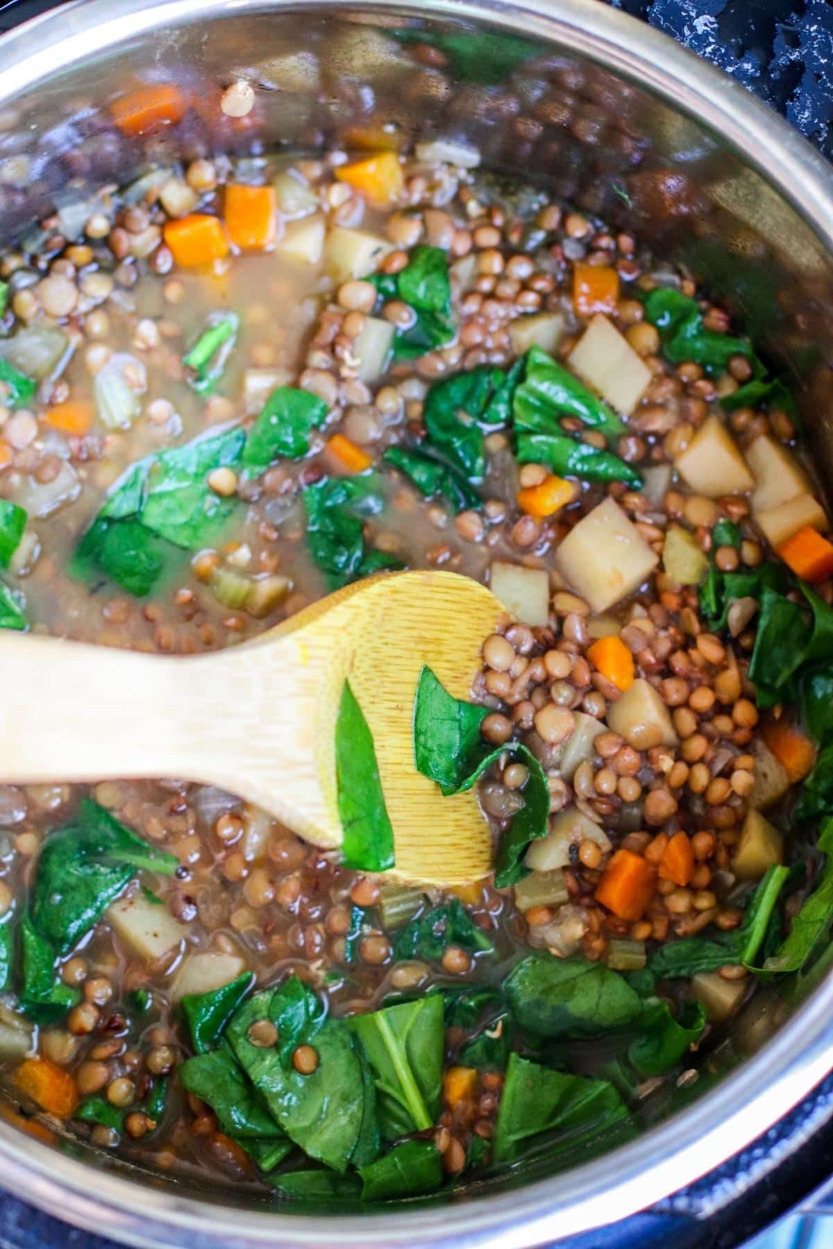 Stirring spinach into the soup.