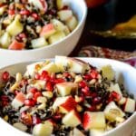 Bowls of wild rice salad with apple and lemon in the background.