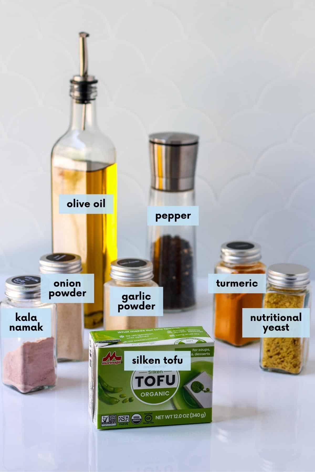 Labeled ingredients needed to make this recipe: Olive oil, pepper, onion powder, garlic powder, turmeric, kala namak, box of silken tofu, and nutritional yeast.