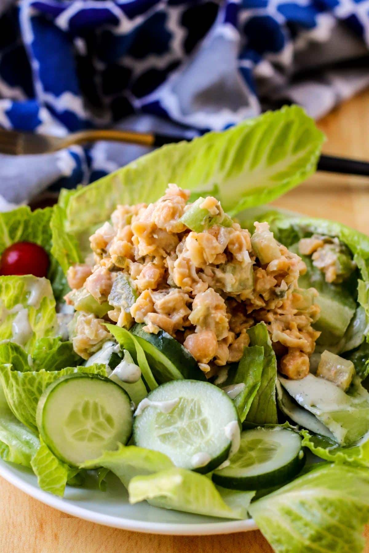 Chickpea tuna salad served on a plate of lettuce, tomatoes, and cucumbers.