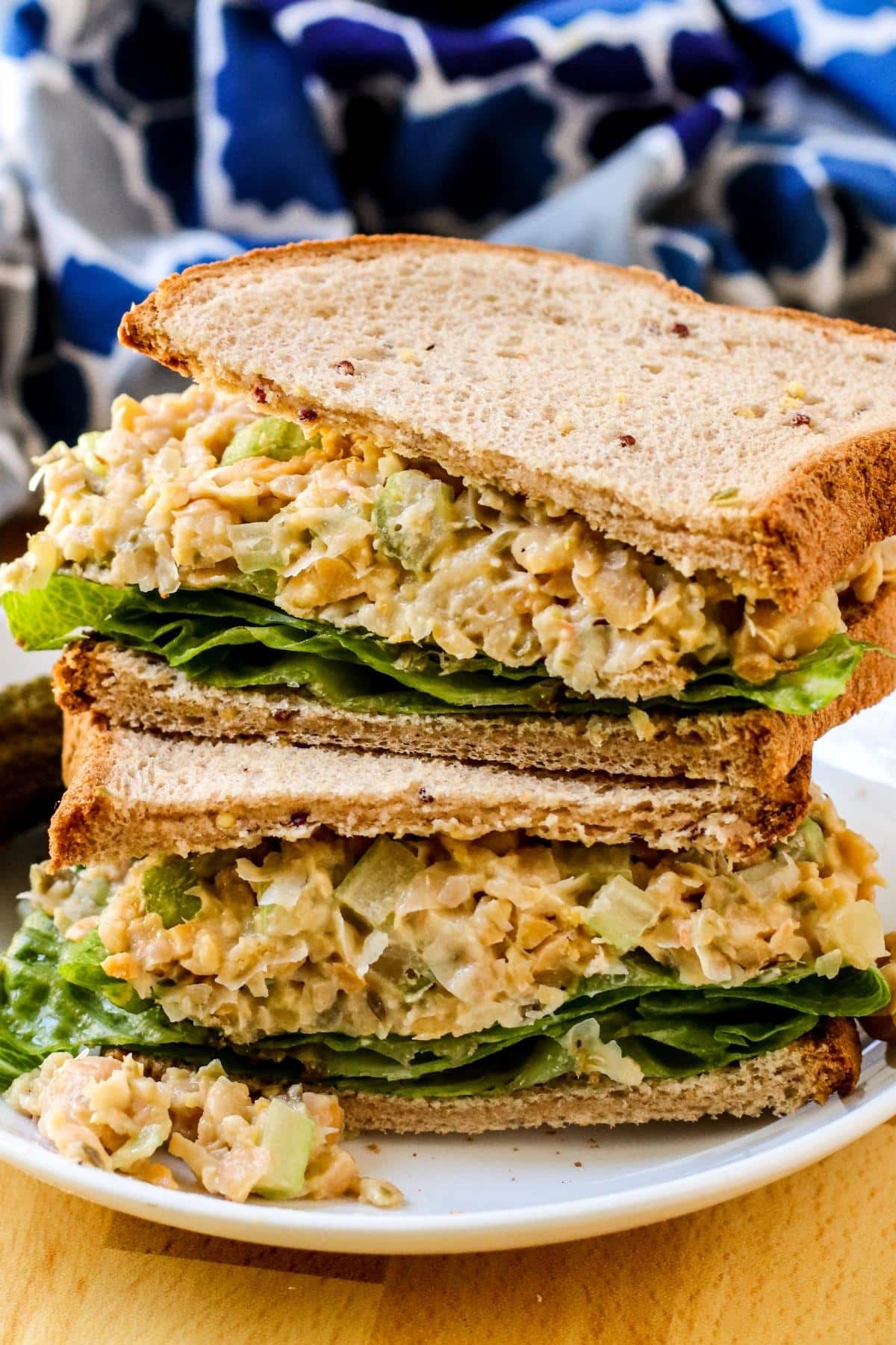 Stacked vegan tuna salad sandwich halves on a plate.