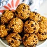 Plate of pumpkin balls with mini chocolate chips on a plate with text overlay No Bake Pumpkin Balls.