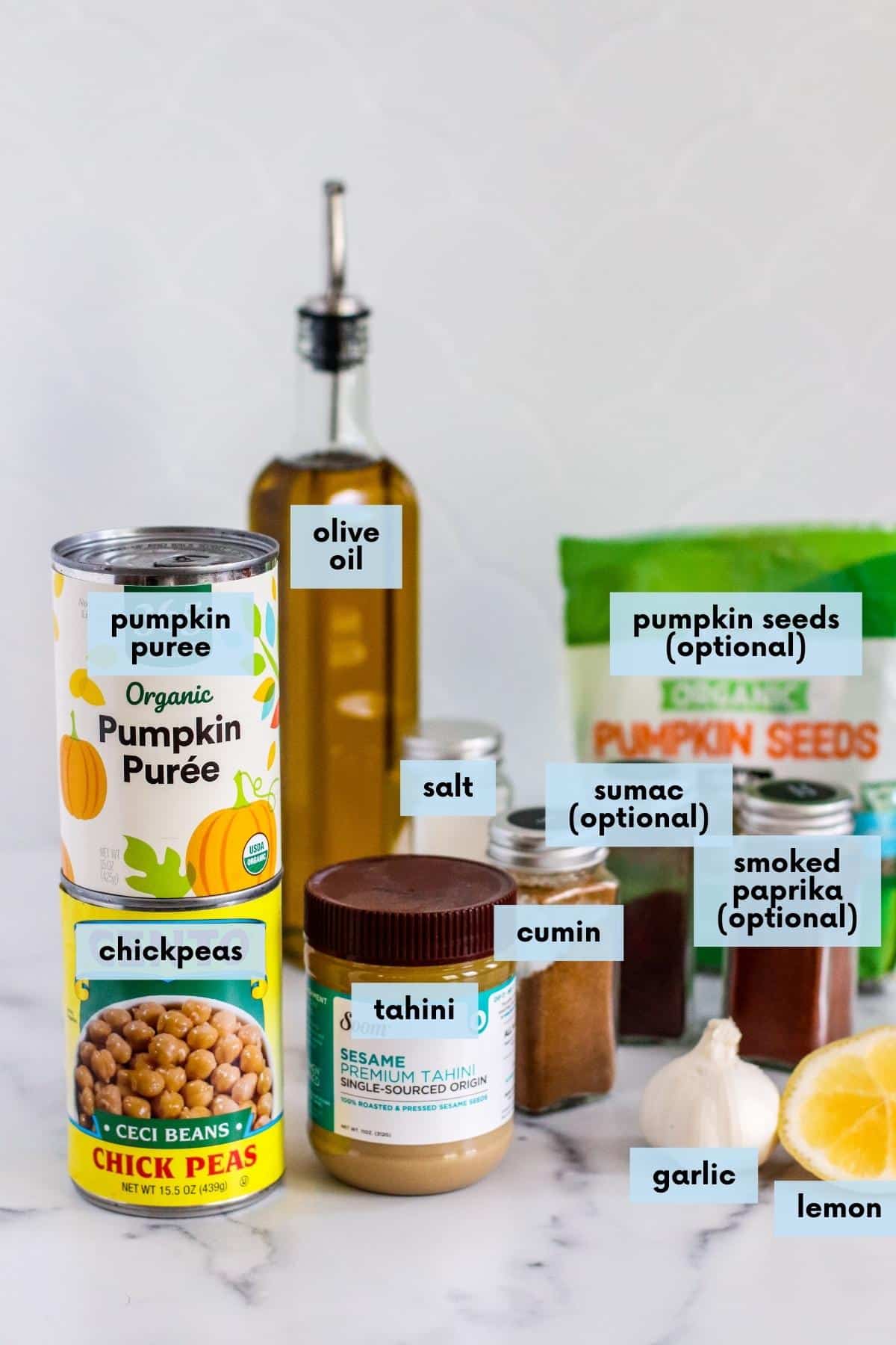 Labeled ingredients needed to make this recipe: Canned pumpkin puree, canned chickpeas, olive oil, hummus, salt, ground cumin, garlic, and lemon and optional ingredients, pumpkin seeds (pepitas), ground sumac, and smoked paprika.