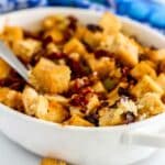 Stuffing in a casserole dish with a serving spoon.