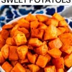 Bowl of roasted sweet potato cubes with text overlay Crispy Roasted Sweet Potatoes.