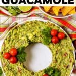 Guacamole appetizer in the shape of a wreath garnished with tomatoes and cilantro with text overlay Christmas Guacamole.