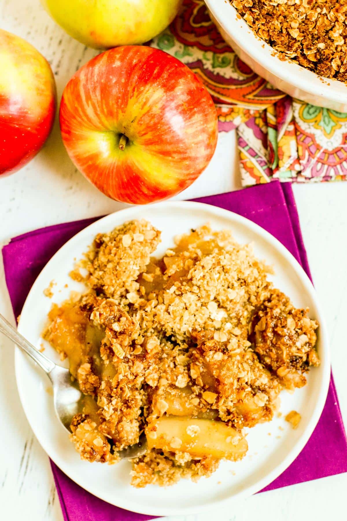 Serving of apple crisp on a plate with a dessert spoon.