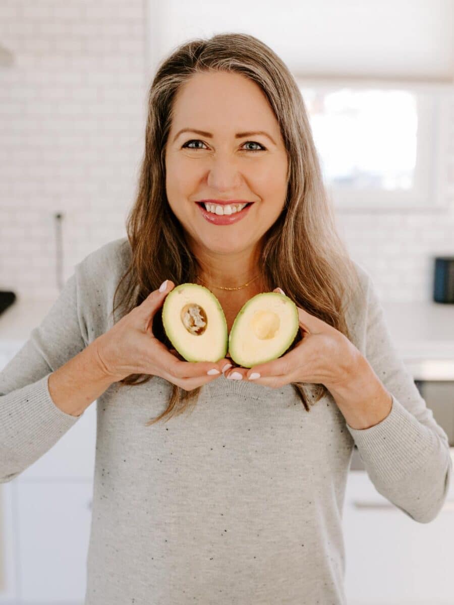 Amy holding halves of avocado like a heart.