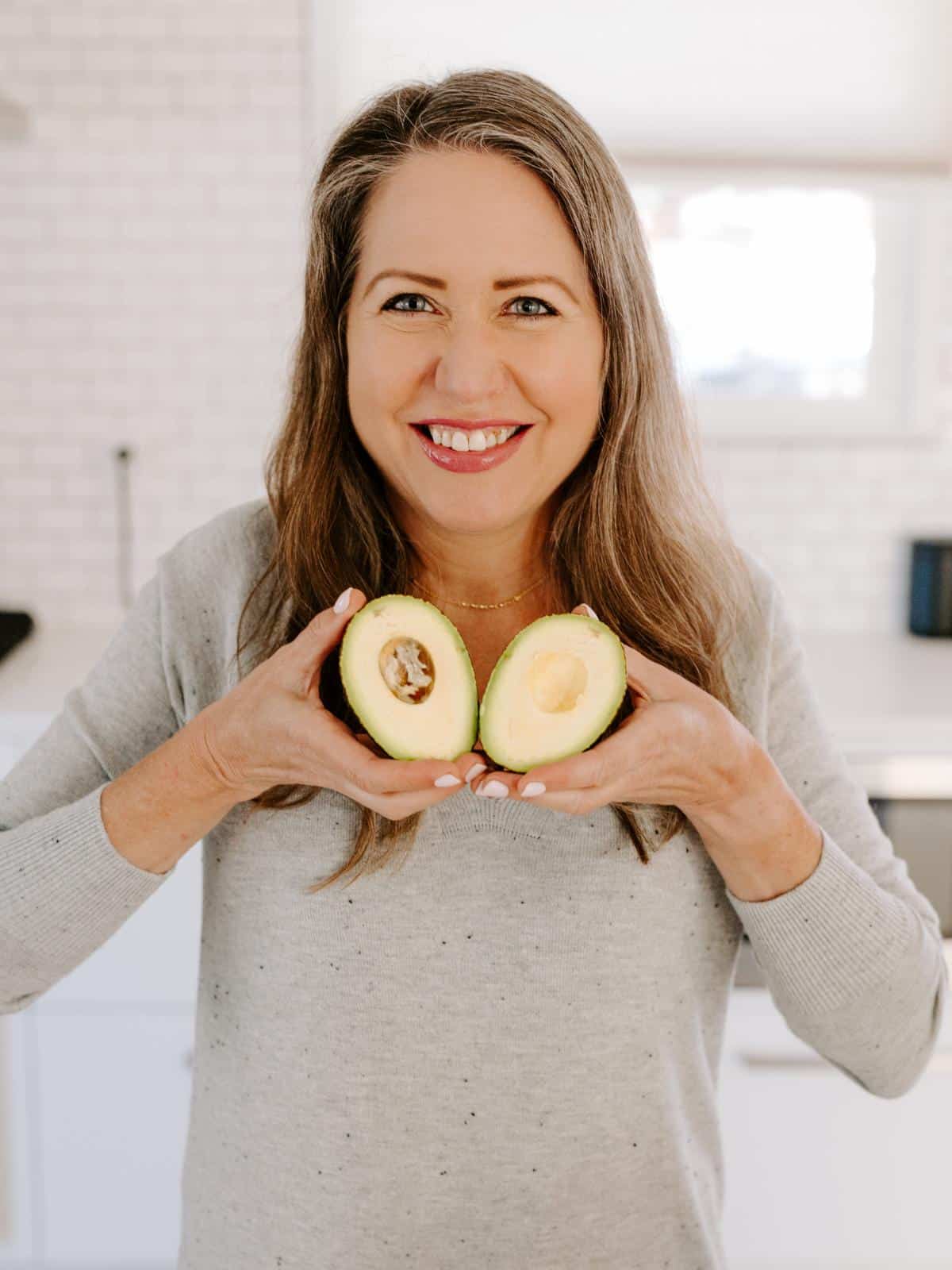 Amy holding halves of avocado like a heart.