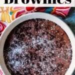 Brownies in a baking dish topped with mini chocolate chips and powdered sugar.