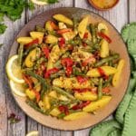 Bowl of Green Bean Potato Salad garnished with lemon slices.