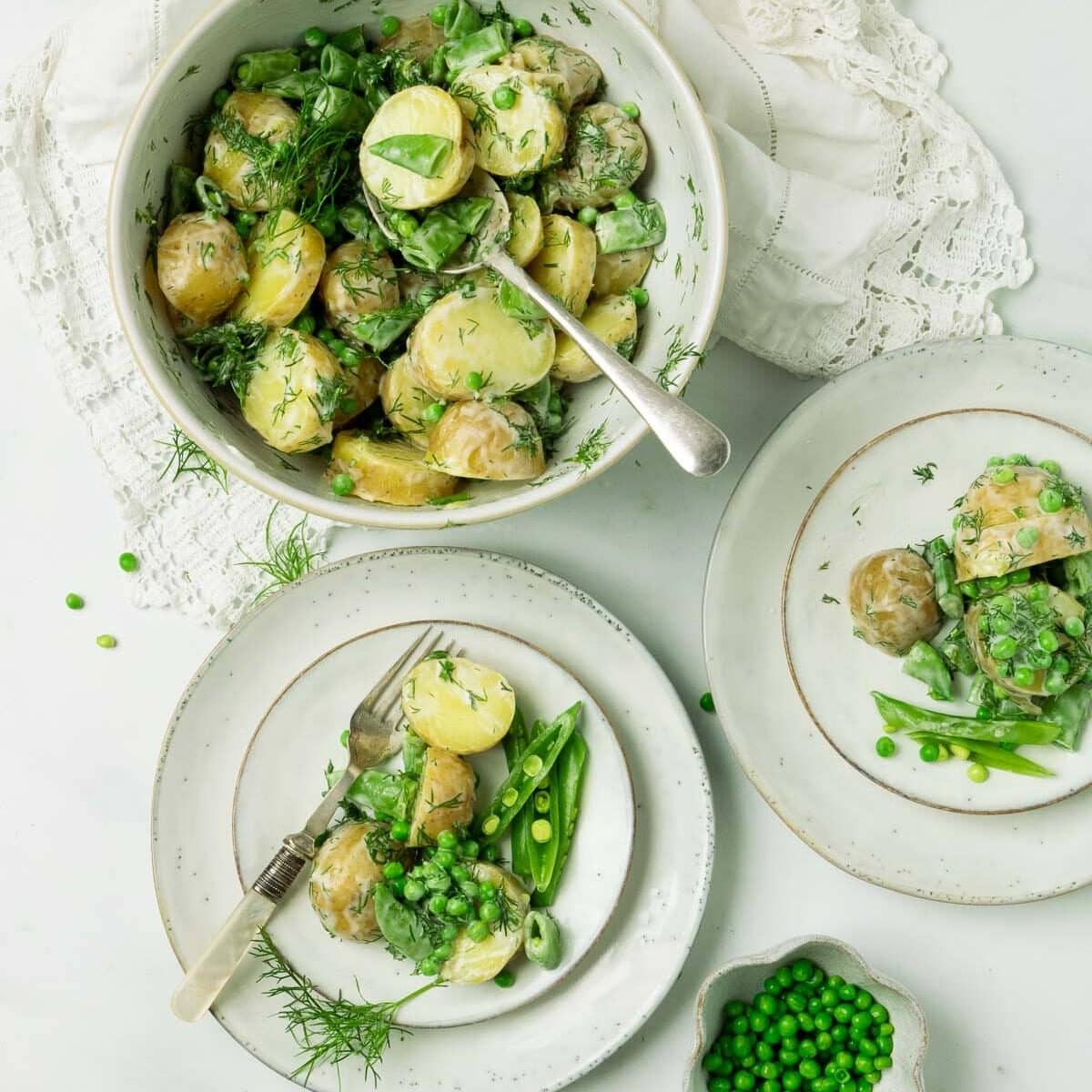 Serving bowl and individual servings of Potato Salad with Dill and Peas.