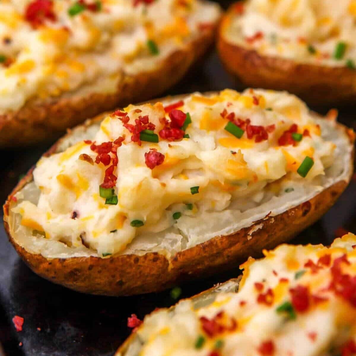 Baked potatoes topped with vegan cheese, sour cream, and bacon bits.