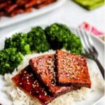 Plate of baked teriyaki tofu with rice and steamed vegetables.