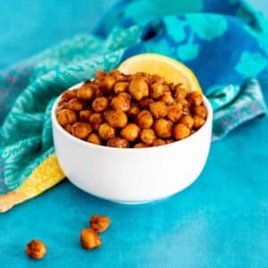Bowl of pan fried chickpeas garnished with a lemon wedge.