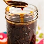 Spoon of sauce over a jar with text overlay Oil-Free, Gluten-Free Vegan Teriyaki Sauce.