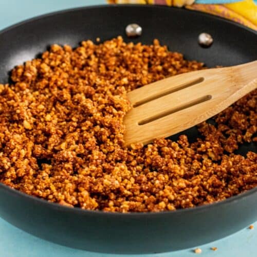 Sauteing walnut meat crumbles in a skillet.