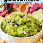 Bowl of guacamole dip with tortilla chips on the side and text overlay 4 ingredient guacamole.