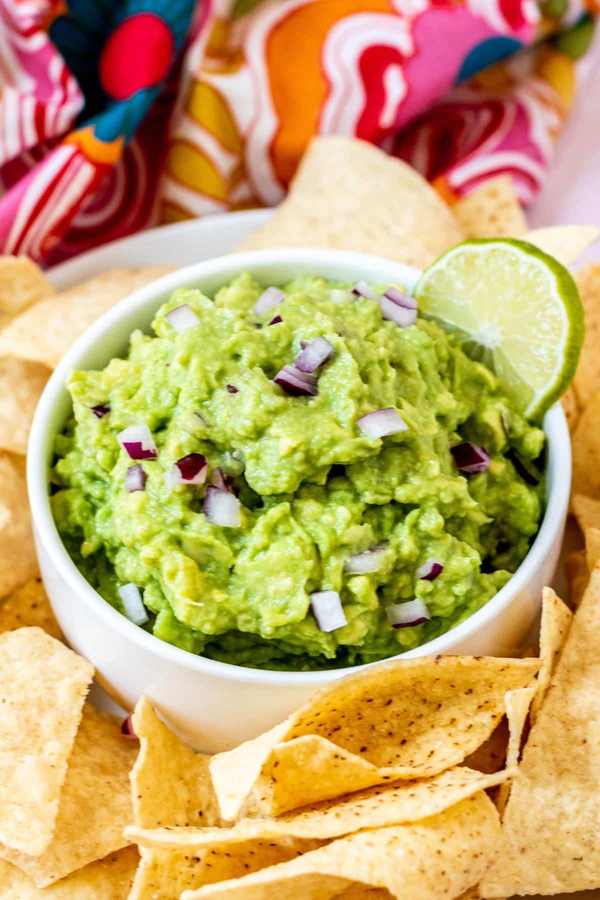 Bowl of guacamole with tortilla chips on the side.