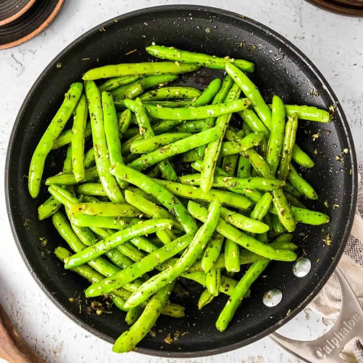 Sauteed green beans in a skillet.