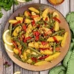 Serving bowl of Green Bean Potato Salad garnished with lemon slices.