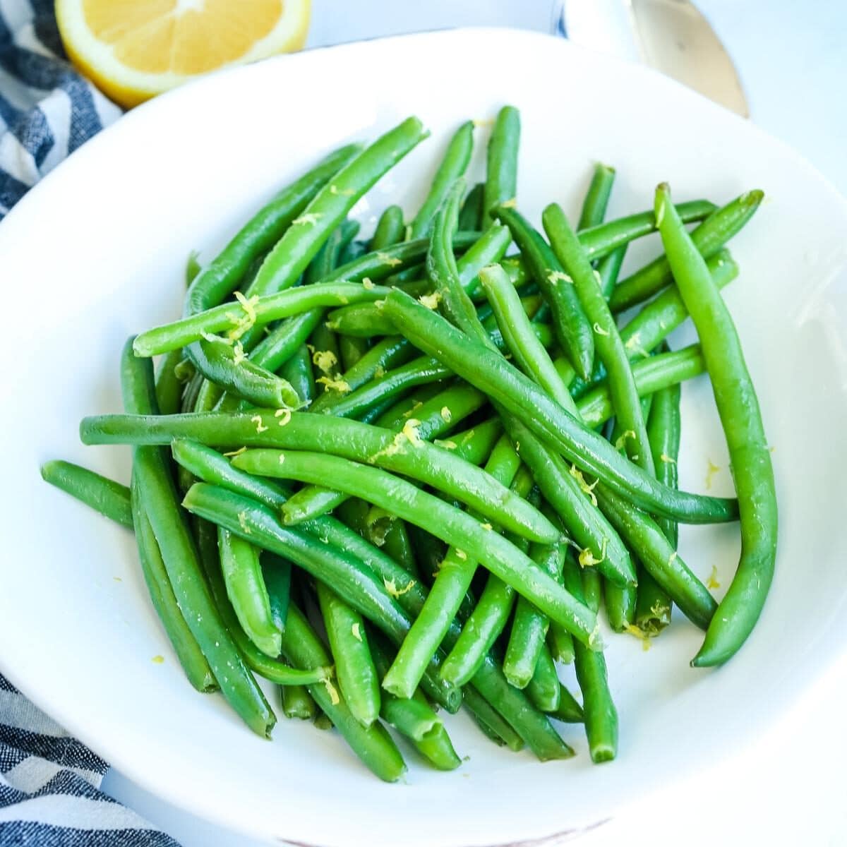 Plate of green beans topped with lemon zest.