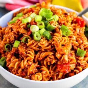 Bowl of vegan taco pasta topped with sliced green onions.