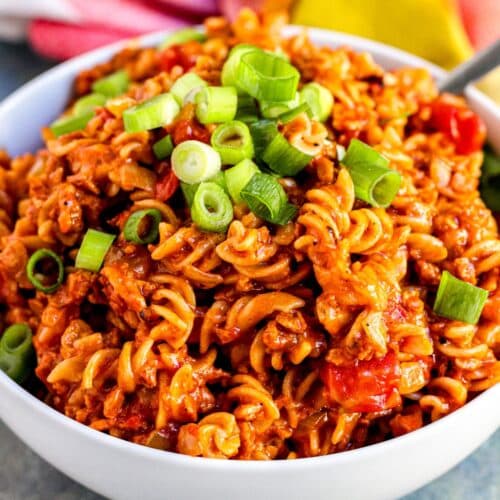 Bowl of vegan taco pasta topped with sliced green onions.