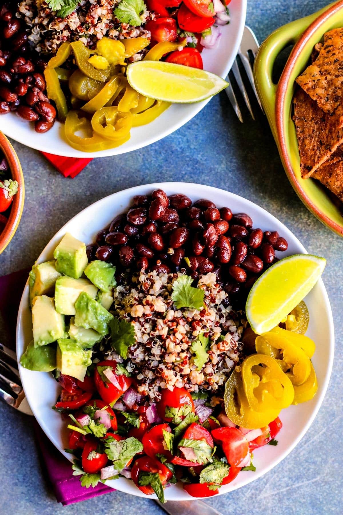 A burrito bowl with cilantro lime quinoa, black beans, pico de gallo, avocado, and pickled hot peppers.