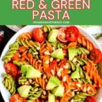 Bowl of rotini pasta topped with cherry tomatoes, avocado, and pine nuts with text overlay Vegan Christmas Red & Green Pasta.