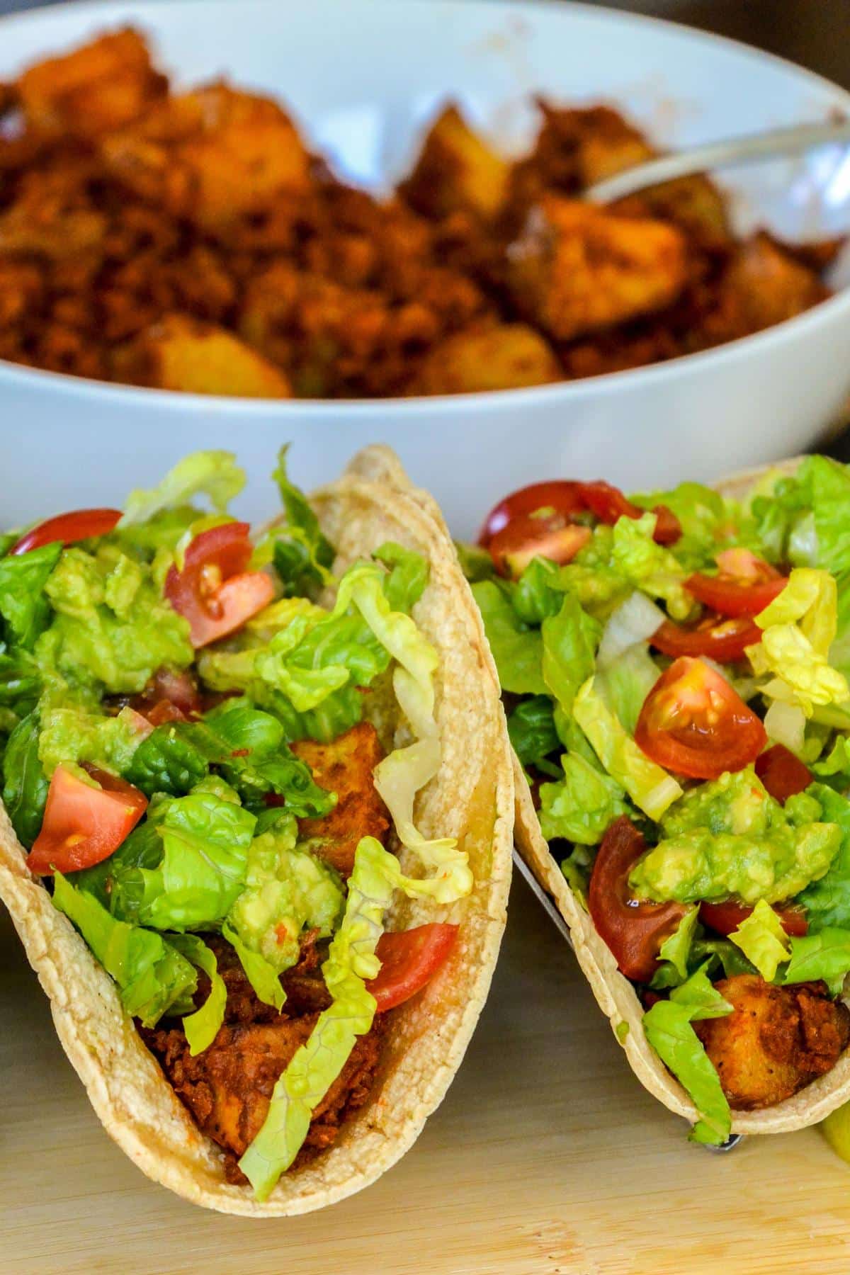 Assembled tacos and soyrizo-potato filling in a bowl.