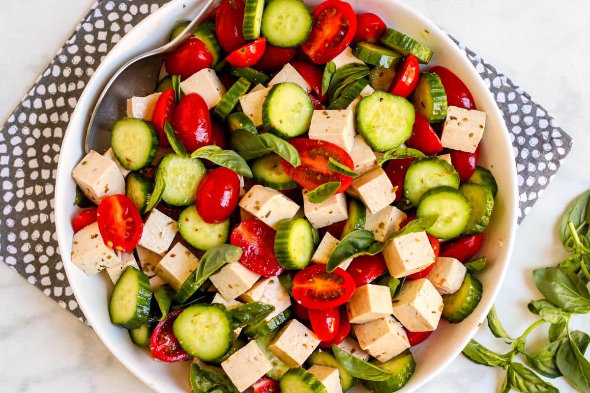 Bowl of Vegan Tomato Basil Cucumber Salad with Tofu Feta.