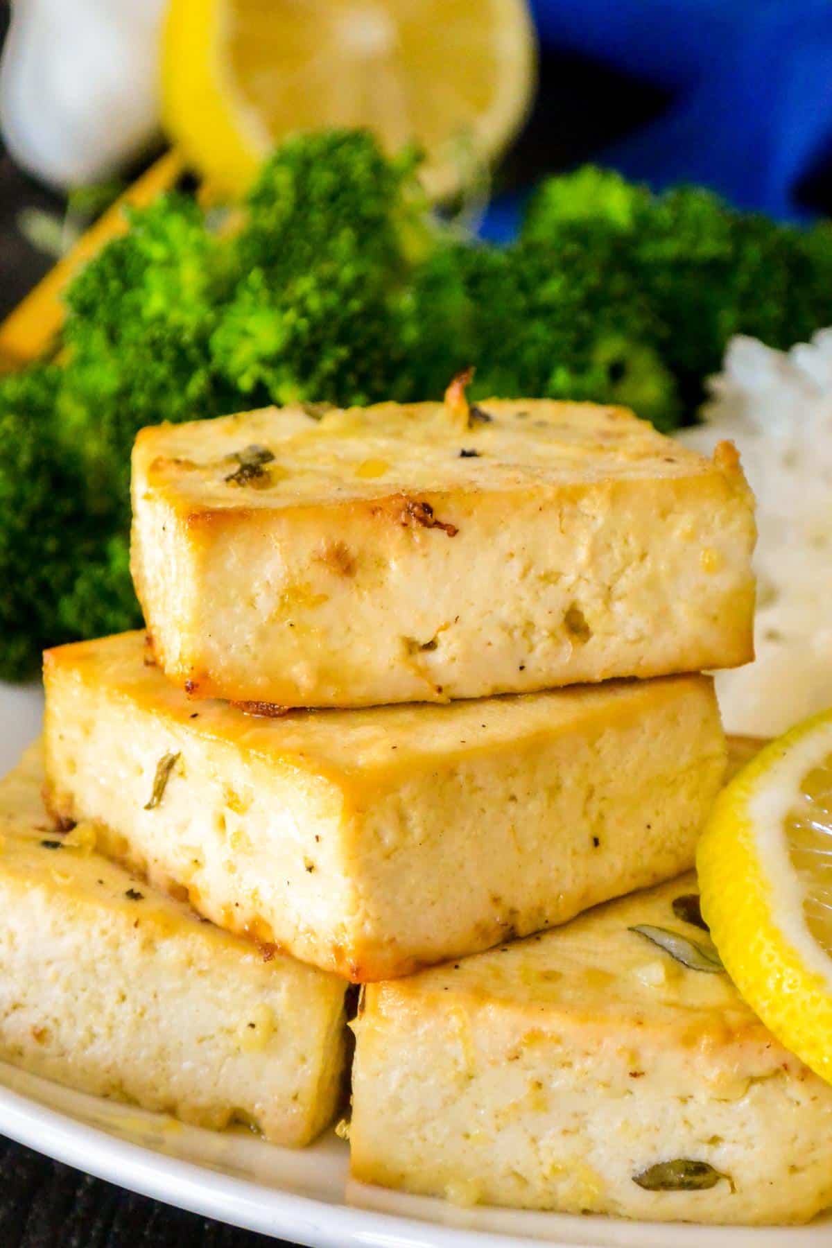 Baked tofu steaks and steamed broccoli on a plate.