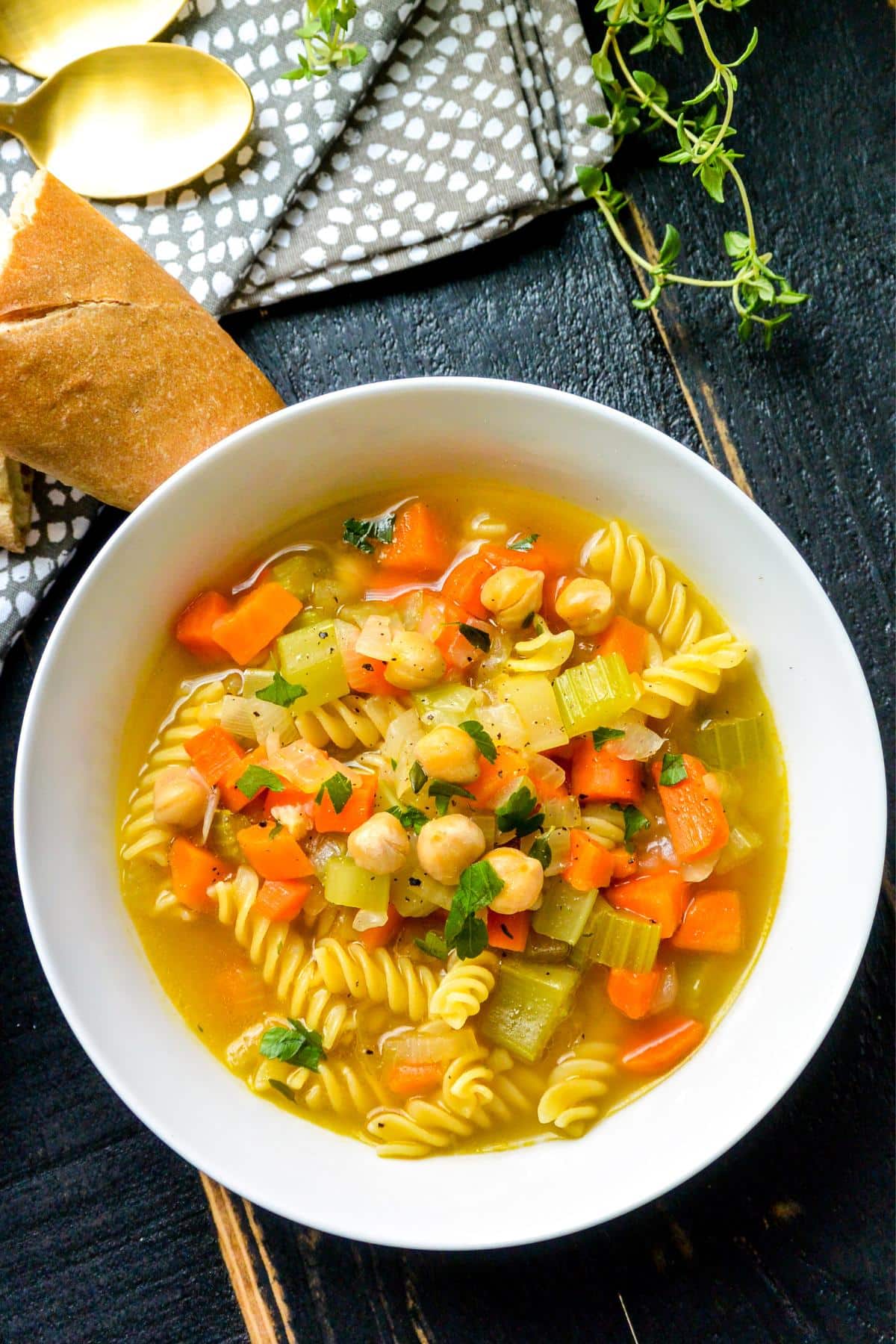 Bowl of soup with piece of baguette on the side.