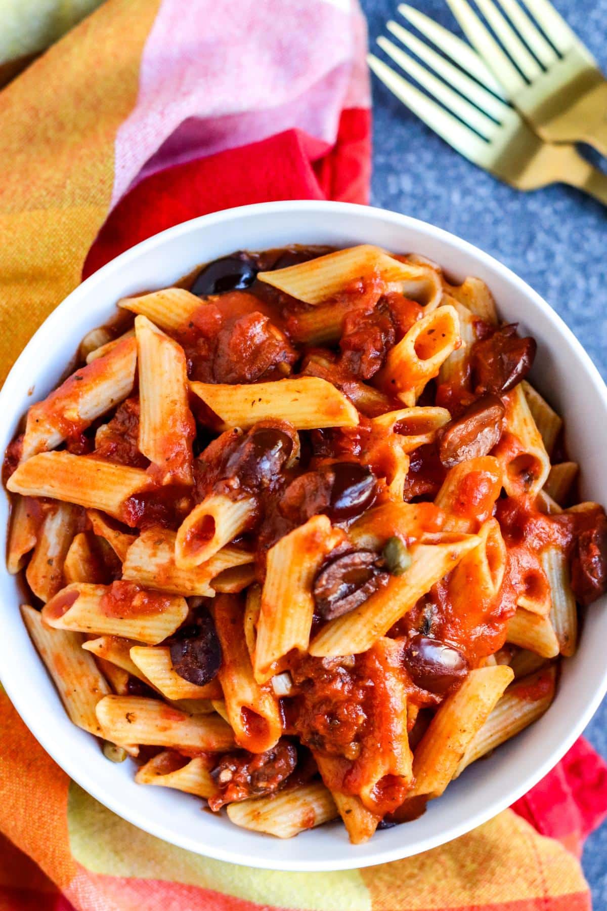 Bowl of penne with vegan puttanesca sauce.