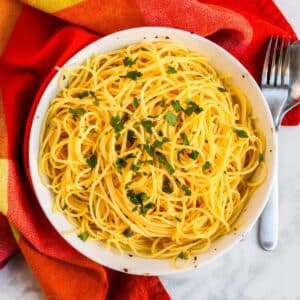 Bowl of spaghetti garnished with fresh parsley.