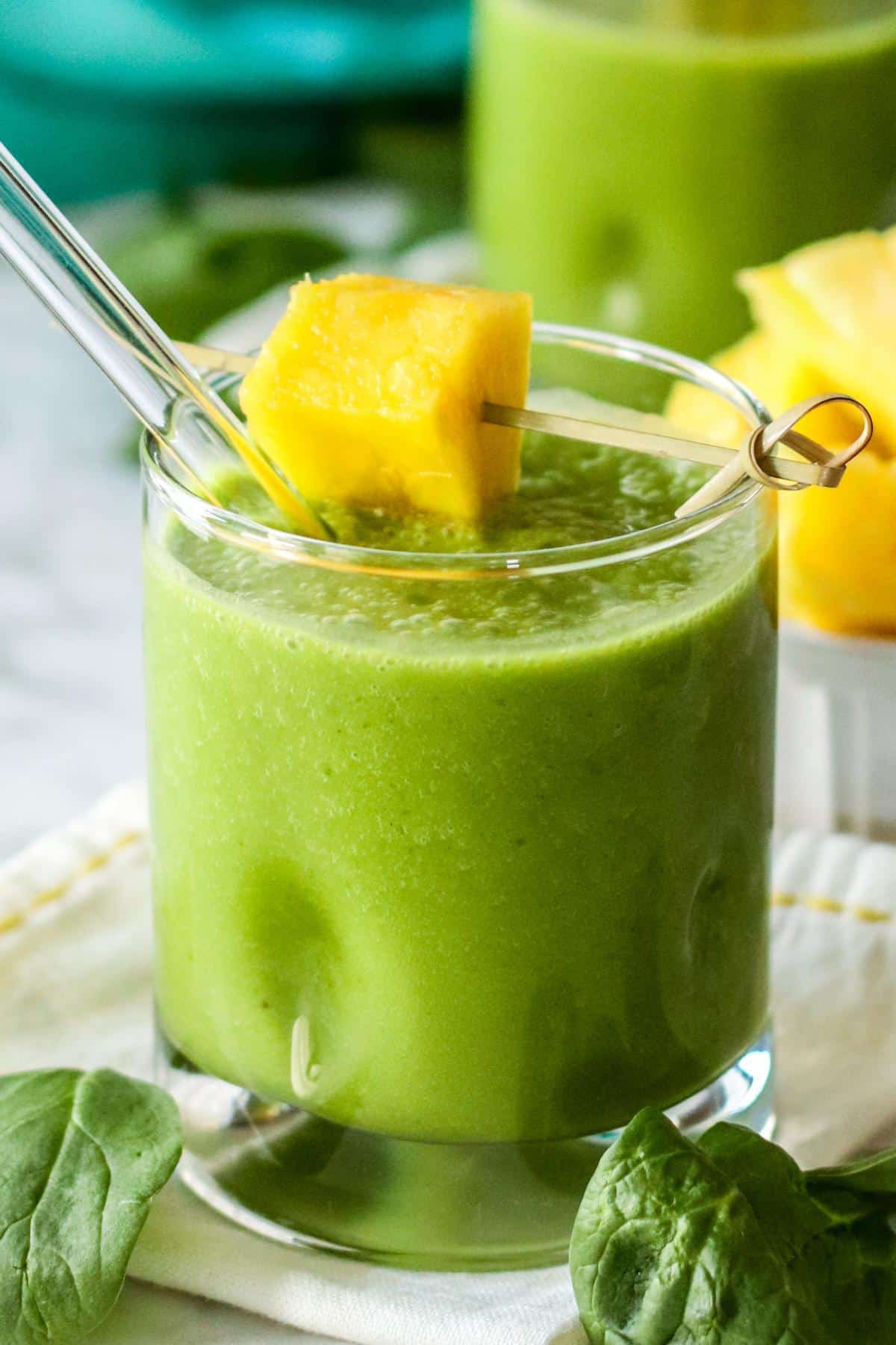 Green smoothie with pineapple garnish.