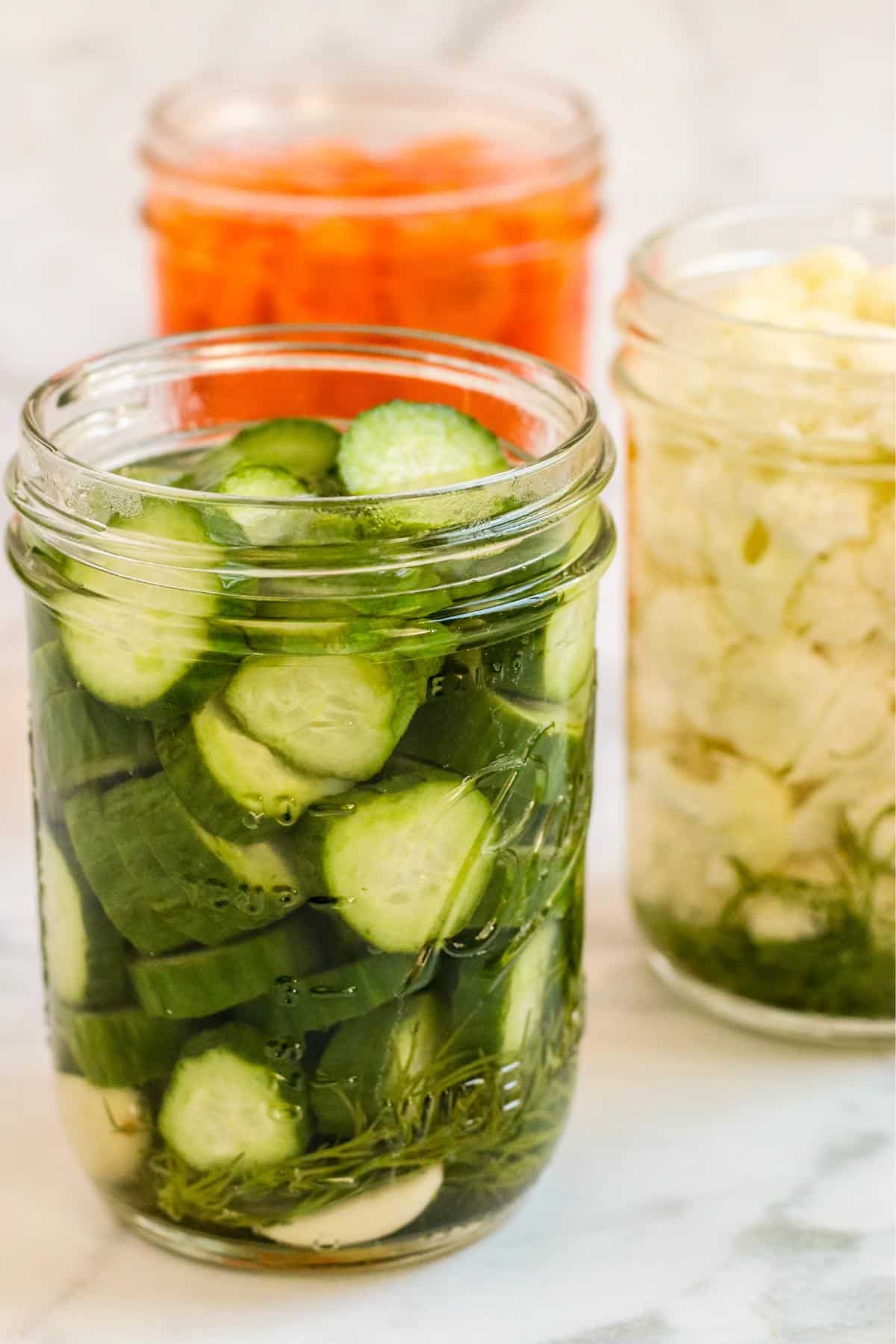 Jars of pickled cucumbers, carrots, and cauliflower.