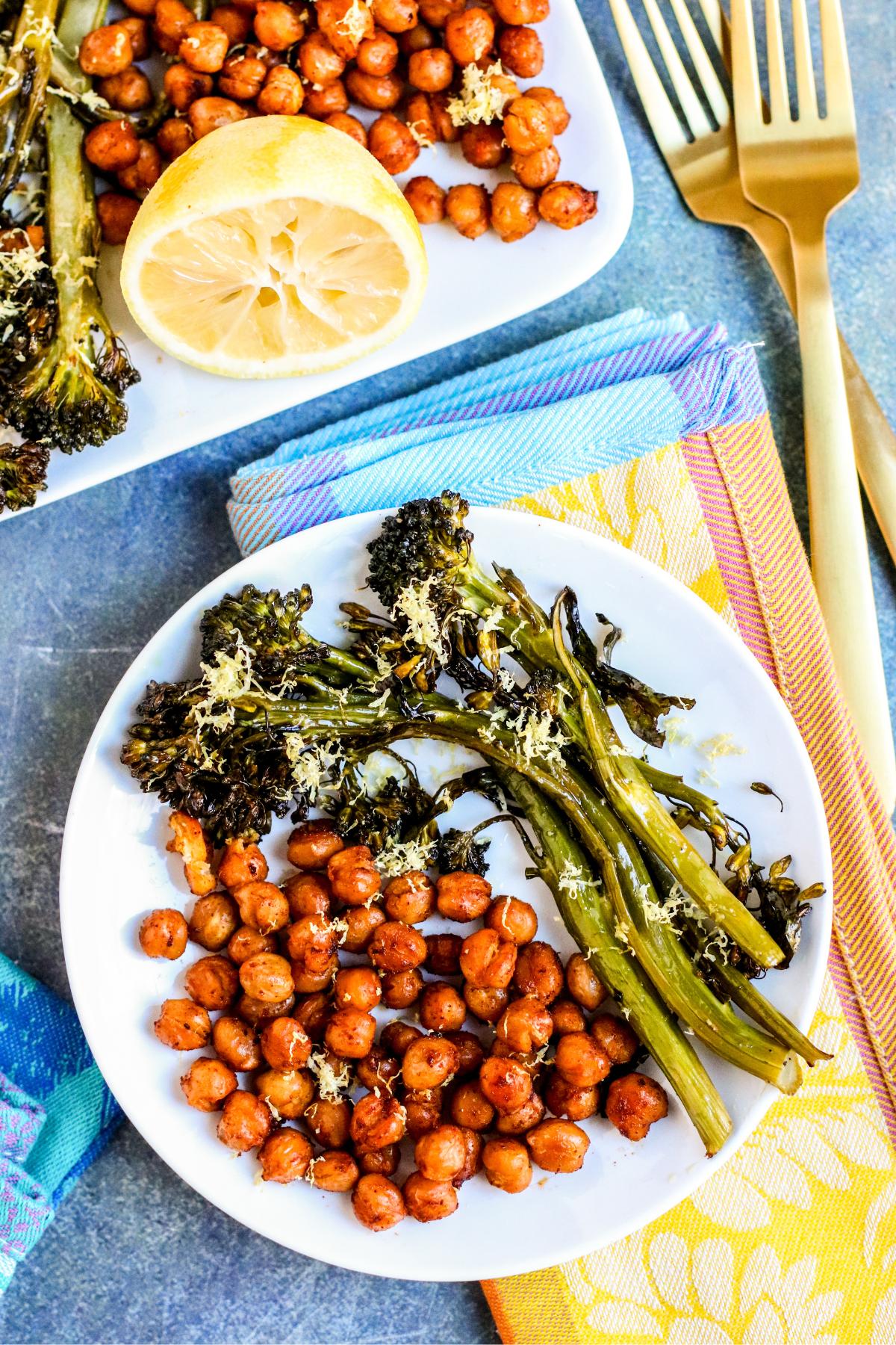 Plate with seasoned roasted chickpeas and broccolini garnished with lemon zest.